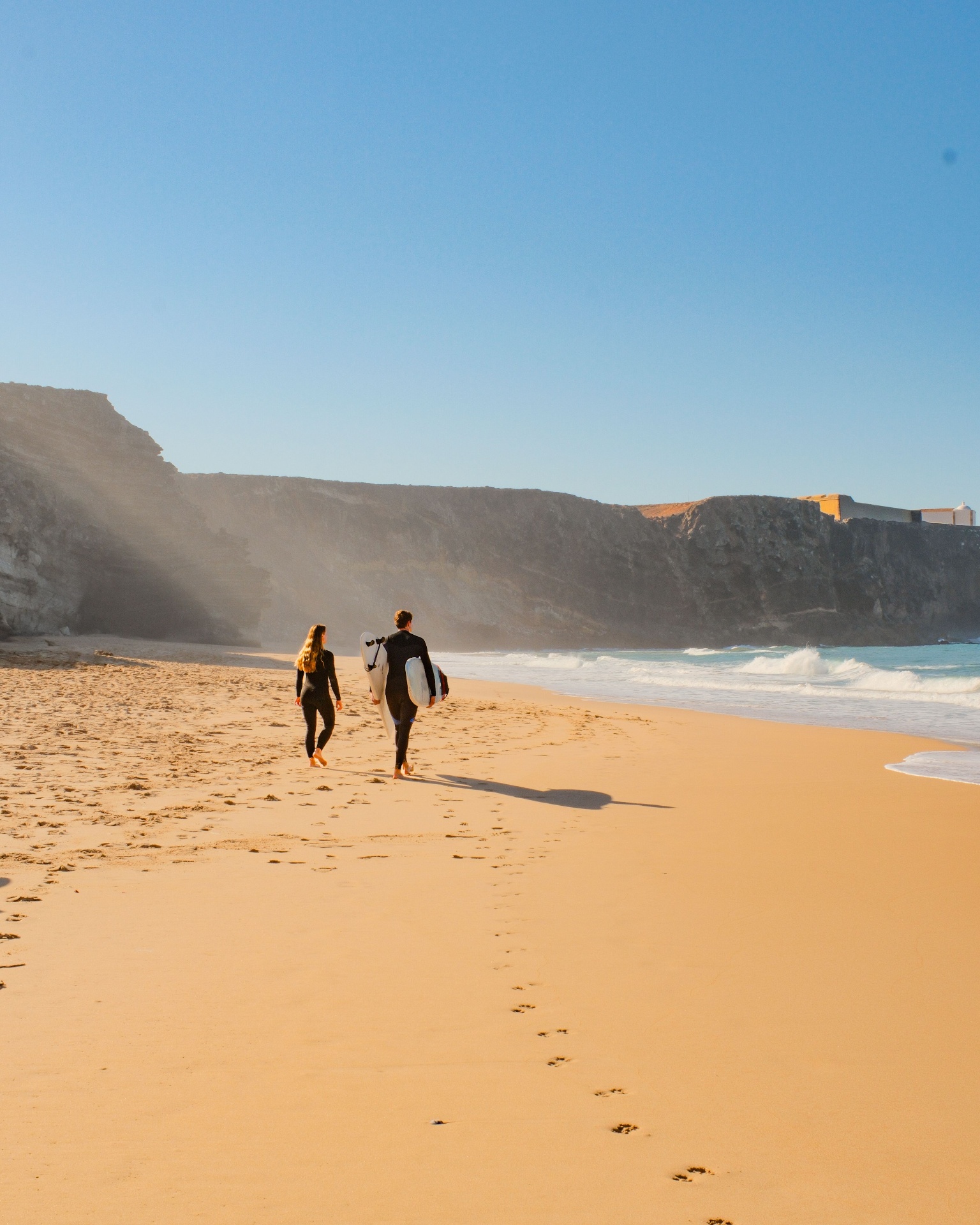 Two surfers walking on a wild Costa Vicentina beach